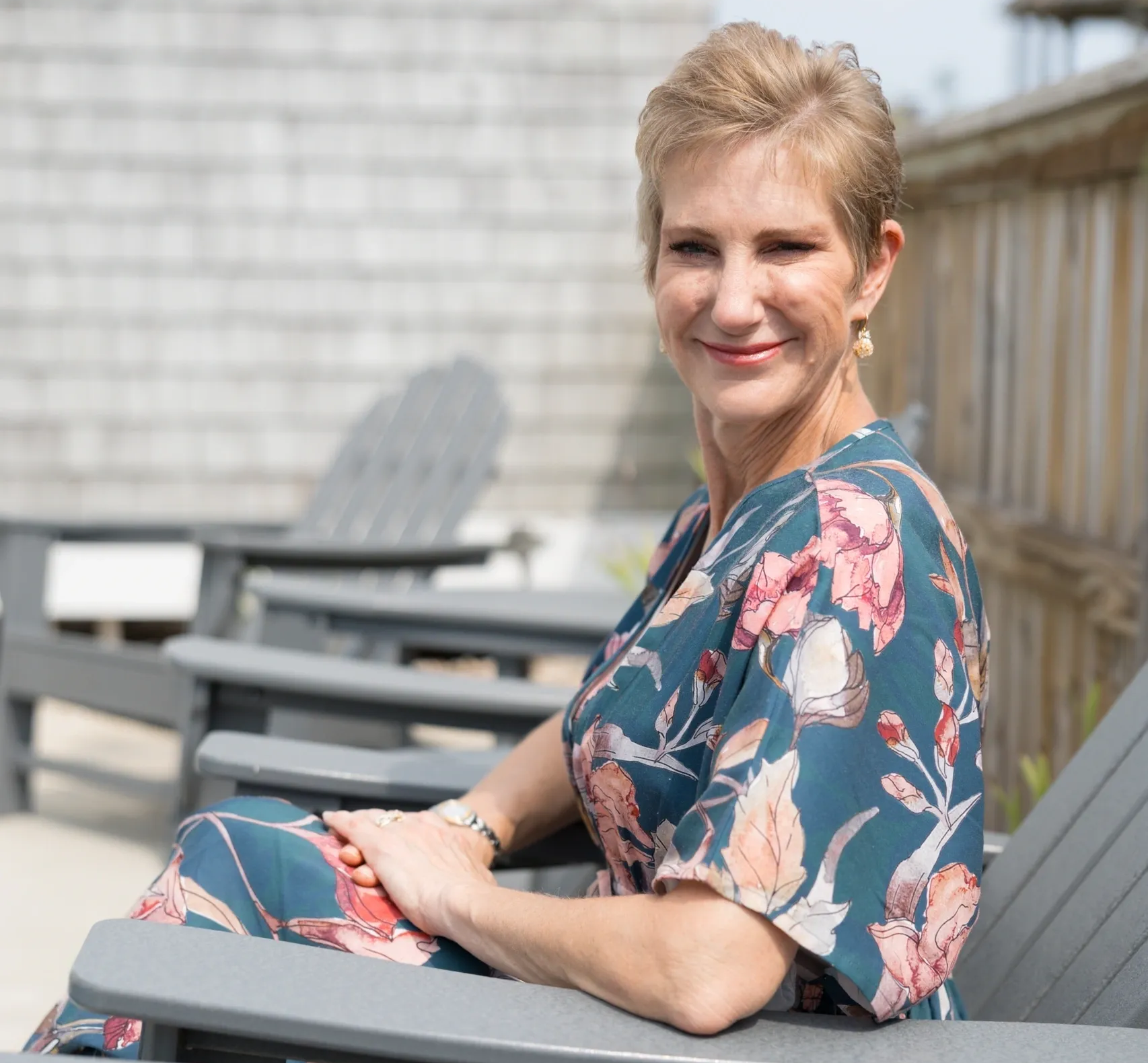 A woman sitting on top of a wooden bench.