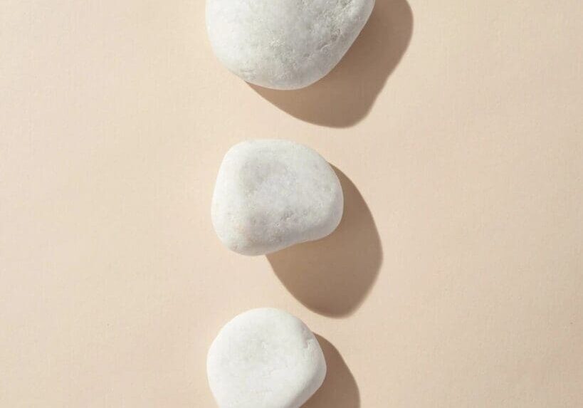 qtq80-sD2HCq Three white stones are on a beige surface.
